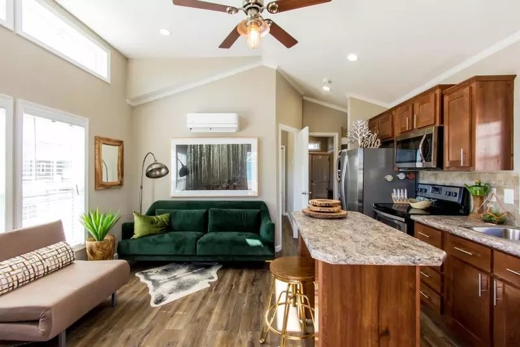 Inside view of a tiny home with a kitchen and two small couches.