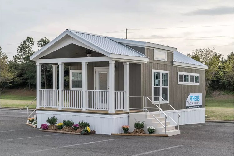 A tiny home with a front porch and stairs leading up to the entrance.